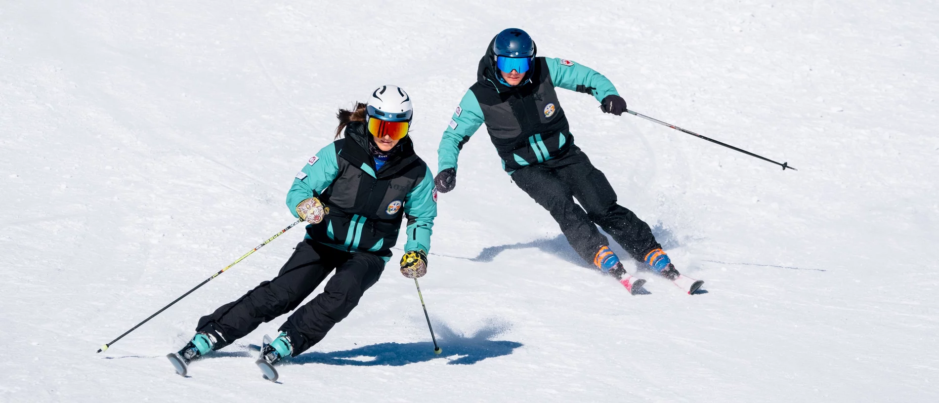 [Translate to English:] Zwei Skilehrer der ROC Skischule beim Carven