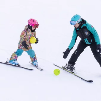 Skilehrerin mit Kind auf der Piste