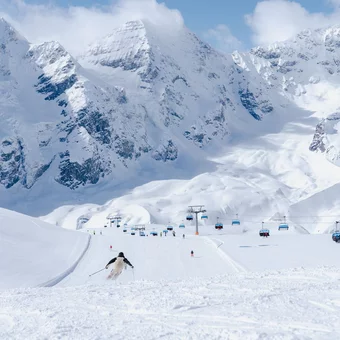Skifahrer auf der Piste mit Bergpanorama
